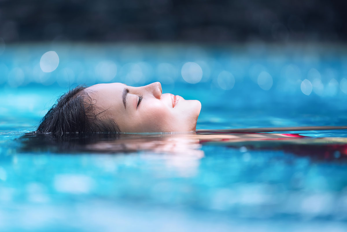 Eine Frau schwimmt entspannt im Schwimmbecken