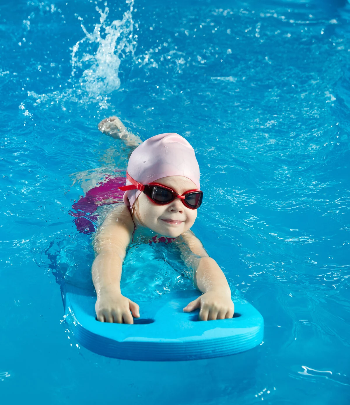 Ein Kind mit Schwimmbrille schwimmt im Wasser